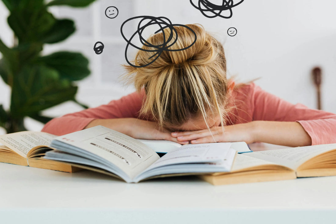 Brouillard mental : étudiante reposant la tête sur ses devoirs