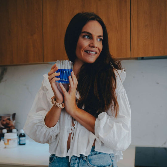 Femme avec verre de phycocyanine